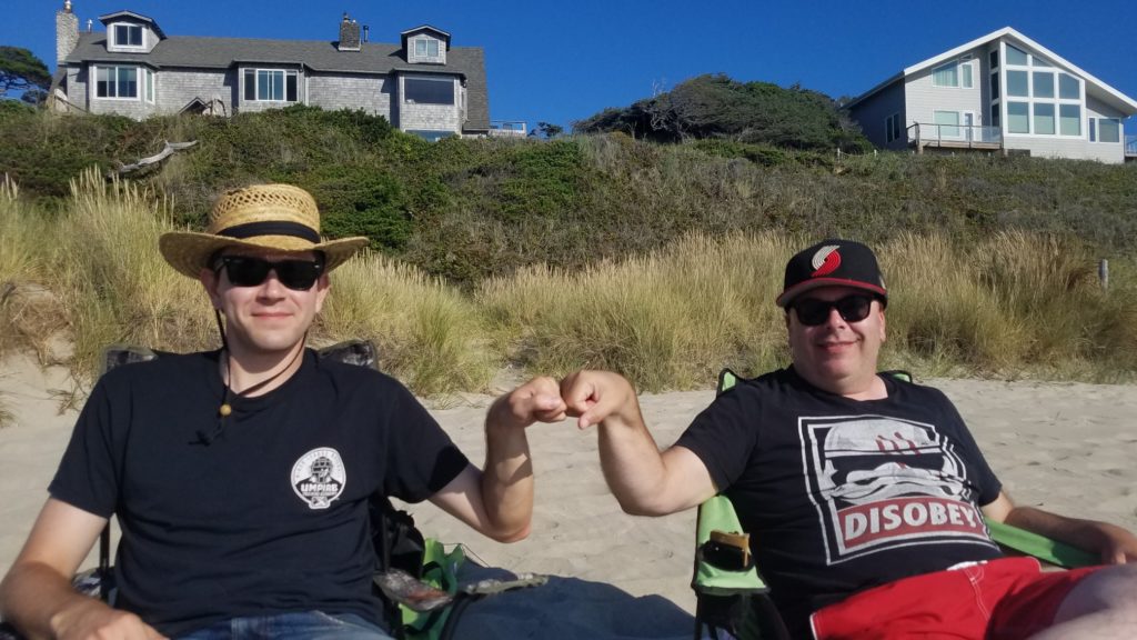 A picture of Max and Brian (the author), sitting on the beach, smiling, bumping fists.